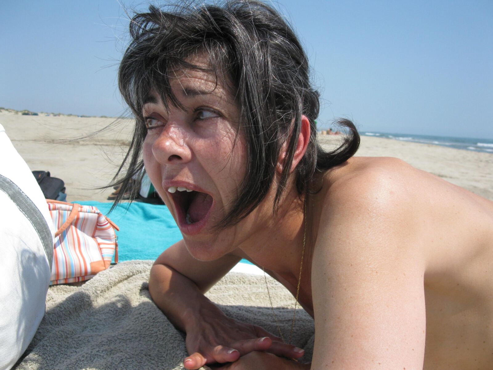Skinny mature Beatrice on beach smiling and spreading legs HD
