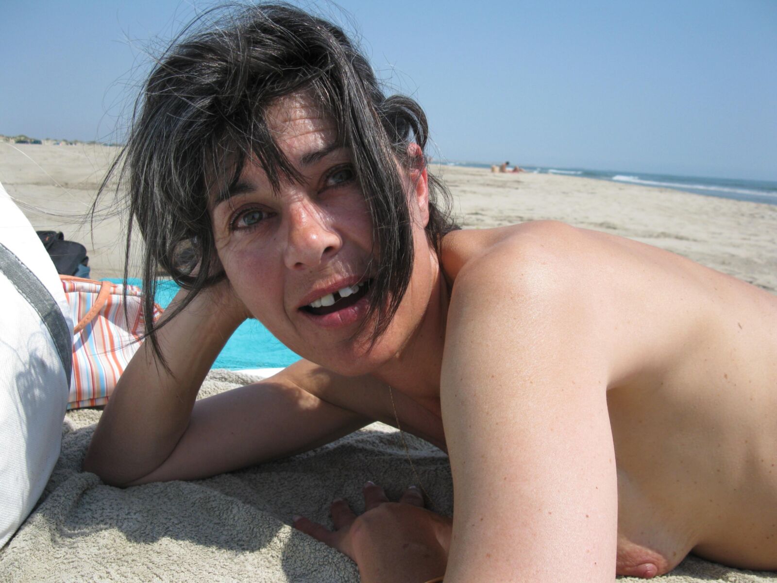 Skinny mature Beatrice on beach smiling and spreading legs HD