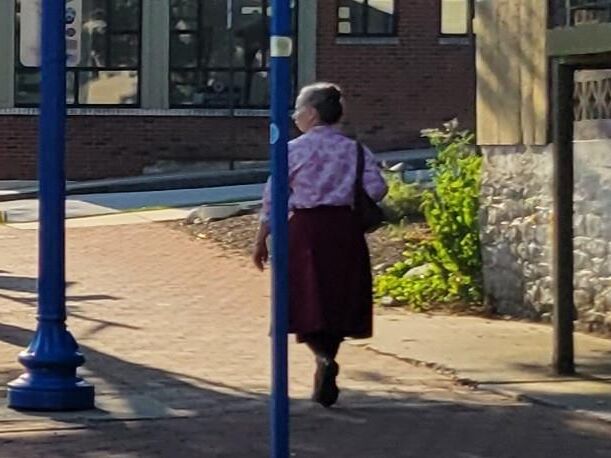 Anciana en pantimedias caminando por la calle (sincera)