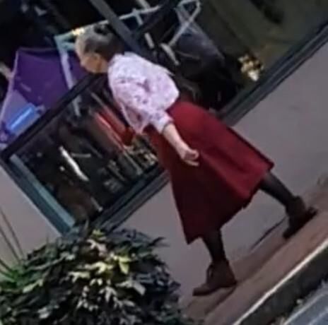 Anciana en pantimedias caminando por la calle (sincera)