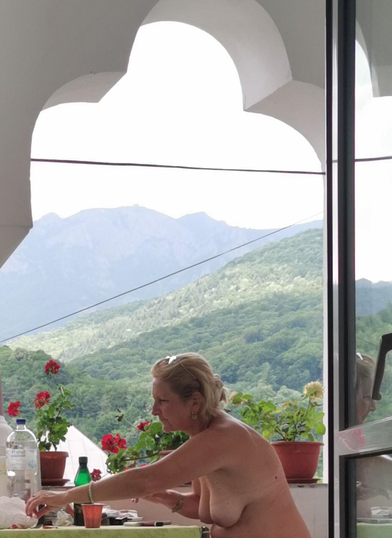 Antiga prostituta Maria de topless na varanda, para visualização pública